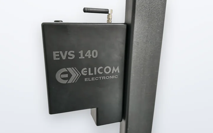 The EVS 140 computing unit on the column: a compact black housing engraved with EVS 140 and the Elicom Electronic logo, with its antenna on top.